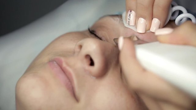 Cosmetologist makes ultrasonic cleansing facial