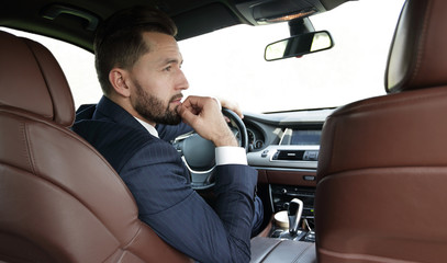 Confident businessman in his car.