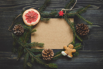 Christmas background. Christmas decoration with fir branches and gingerbread man cookie on the wooden table.