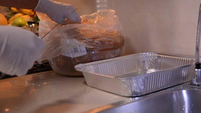 men hands in white gloves prepering raw chicken hearts for bbq on kitchen
