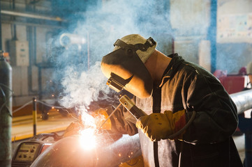 Welders working at the factory made metal - obrazy, fototapety, plakaty