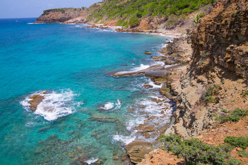 Obraz premium Tropical warm water of Caribbean sea with transparent sea bottom and rocks. Antigua, Caribbean island 