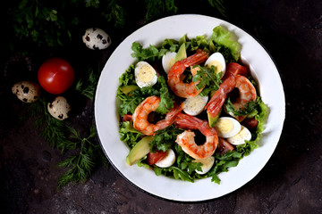 Salad from shrimp tails with lettuce, arugula, quail eggs, cherry tomatoes, avocado, olive oil and balsamic vinegar.
