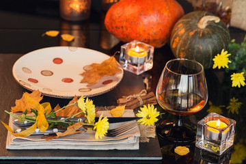 Table setting with autumn decoration for Thanksgiving.