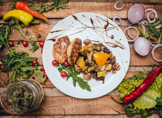 Tasty meat rolls with sour cream and salad on wooden table