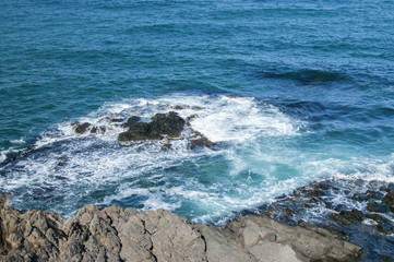 Landscape of rocky seashore with blue calm waters in sunny summer day as natural background