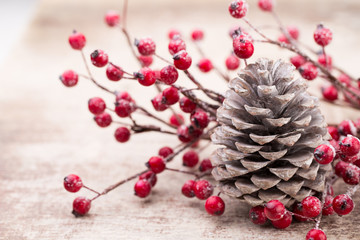 Christmas cone with red berries on a bokeh background.