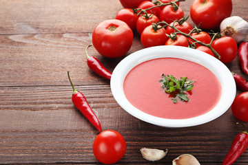 Tomato soup with parsley on wooden table