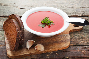 Tomato soup with parsley on wooden table