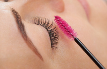 Beautiful Woman with long eyelashes in a beauty salon. Eyelash extension procedure. Lashes close up