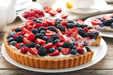 Sweet tart with berries on grey wooden table