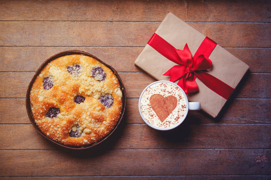 pie and cup of coffee with heart shape with gift boxes