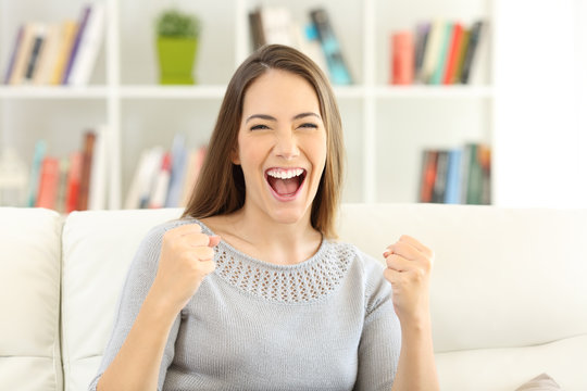Front view of an excited woman looking at camera at home