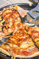 Fresh baked and sliced pizza with mushrooms ketchup ham and cheese