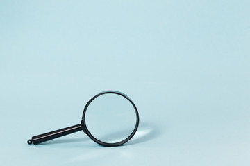 Magnifying glass on a pastel blue background