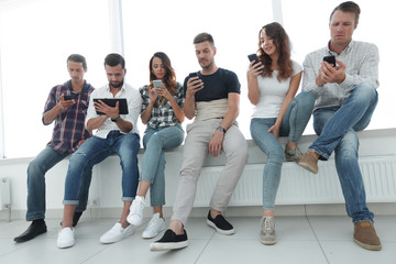 young people in casual clothes using gadgets