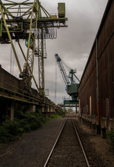 Dark harbour with cranes and train rails