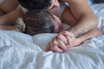 ótimo conceito de orgasmo, sexo, sem vulgaridade, homem segurando mão de mulher na cama