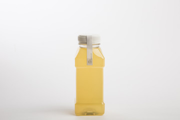 Fresh ginger juice in plastic bottle. White background. Organic nutrition. Detox juice. Small size bottle
