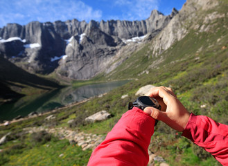 woman hiker checking the altitude with sports watch in mountains