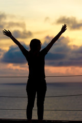 Fototapeta premium Silhouettle woman standing on hill with sunset