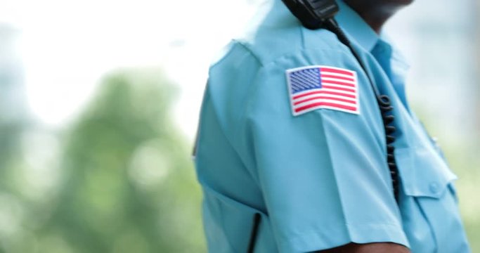 American flag stamped on security guard walking slowly safeguaridng the public protection. Security defender overlooking territory and safeguarding protection