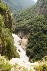 Clean fast river surrounded by mountains, landscape on a sunny day.
