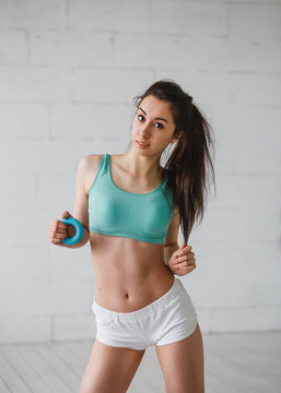 Young woman with expander in gym studio