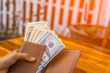 close-up hands  holding us dollar bills. with morning light