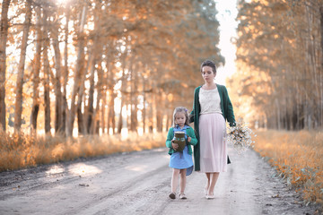 Mother with daughter walking on a road