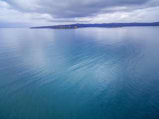 Minimalist aerial landscape - nothing but water, patch of land, and skies