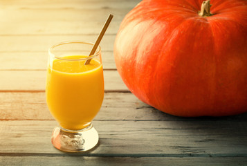 Healthy pumpkin smoothie with sunlight on wooden table