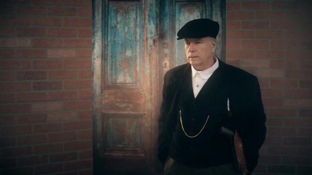 1920 man with pistol walks into a sinister scene next to an old door