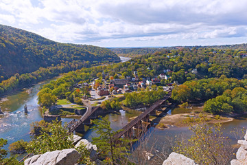Harpers Ferry historic town and National Park as seen from a high mountain point. Harpers Ferry autumn panorama with railroad bridges across Shenandoah and Potomac rivers.