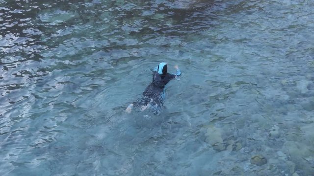 A woman is swimming in the sea.