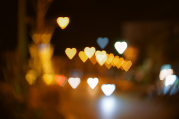 Fototapeta na wymiar Heart shape bokeh from street light background, Love heart background