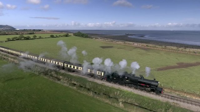 Gorgeous aerial shot of a coastal steam train on the West Somerset steam railway in Blue Anchor, UK.