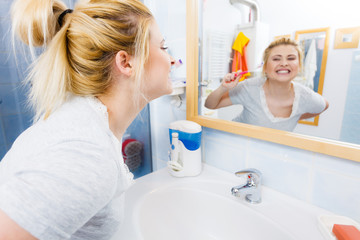 Woman brushing cleaning teeth in bathroom