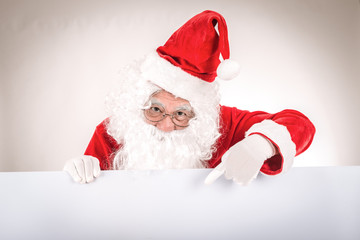 Merry christmas,Santa Claus pointing in white blank sign,Isolated on white background.