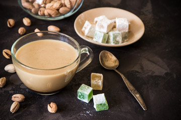 Coffee with milk, pistachios and turkish delight, copy space