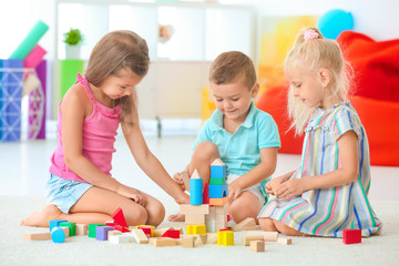 Cute children playing with blocks indoor