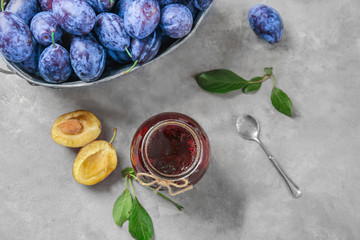 Glass jar with tasty homemade plum jam on table