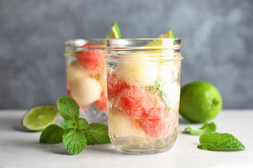 Glass jar with melon ball drink on table