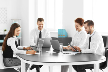 Team of young professionals conducting business meeting in office