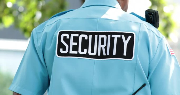 Closeup of security guard standing still safeguarding public. Closeup of man standing with security tag standing on guard