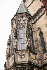 Part of the exterior of the beautiful old temple on the main square in Prague with black roof against gray sky background