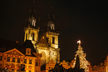Fototapeta premium Decorated Christmas tree stands on the main square in Prague during the New Year holidays. Night view