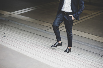 Obraz premium Close up of young businessman walking upstairs outside office.