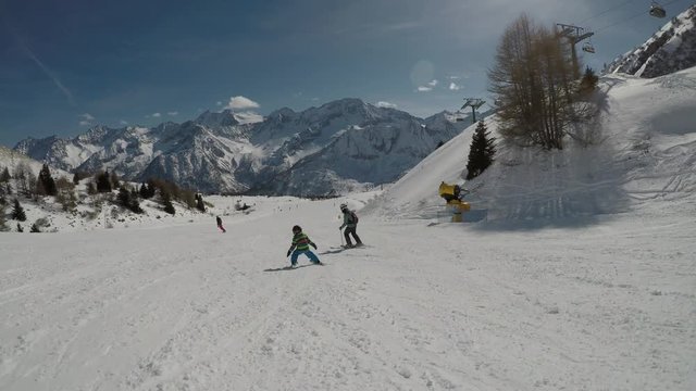 Little boy skiing in the Alps.
Son when skiing. They learn to ski with their parents. Stabilized footage. Slow motion.
