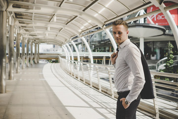 Portrait of happy businessman with hand holding suit, Finish work standing on the way to back home.